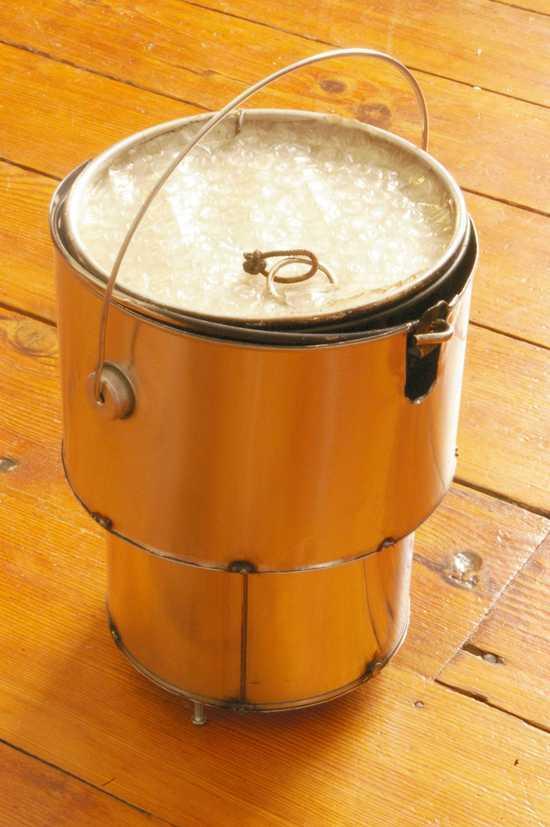 Assembled stove with feet extended and pot in place.