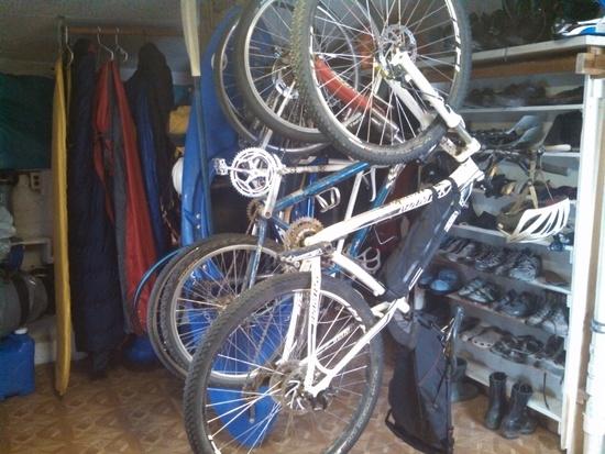 bikes, pads, and bags hanging, shoes on the rack.